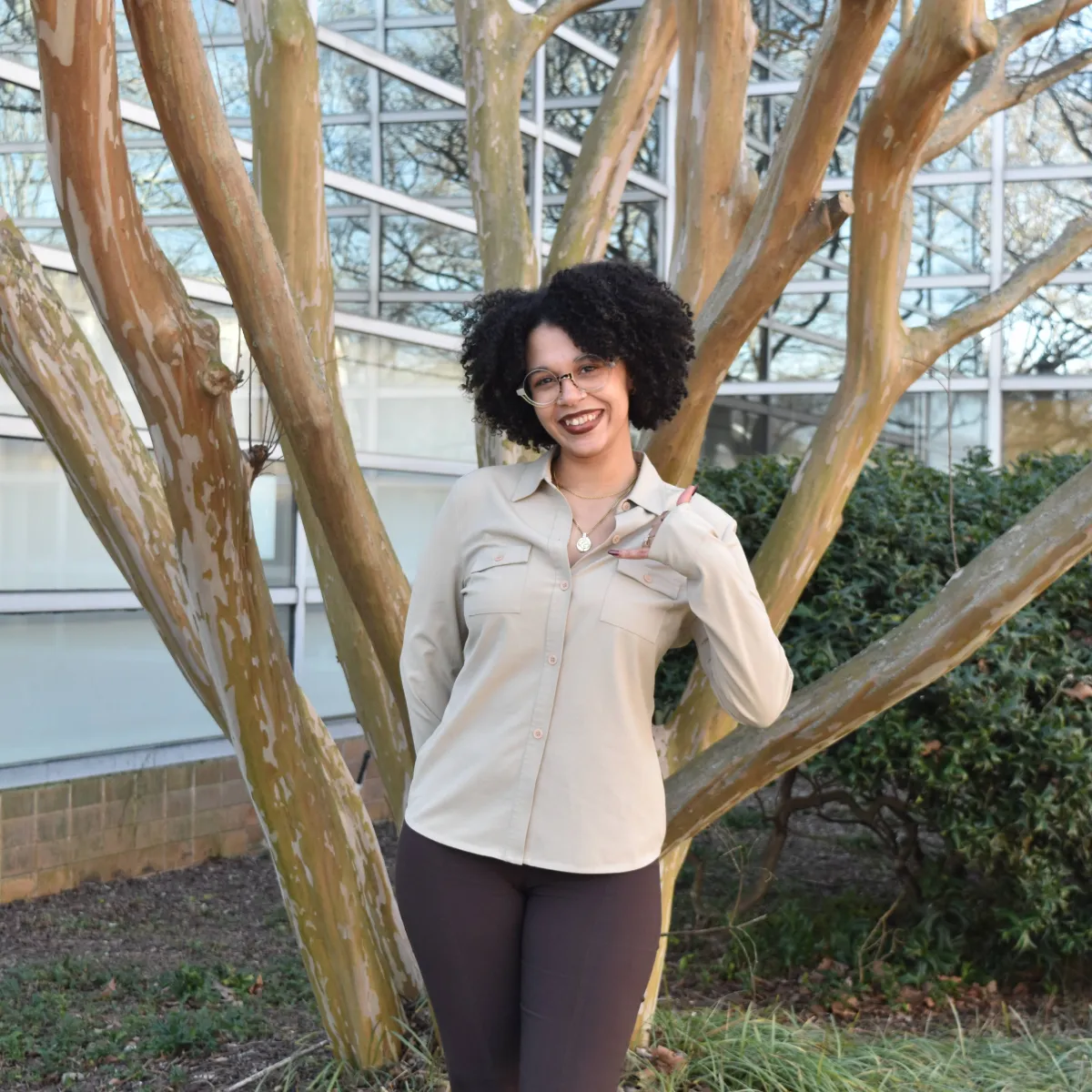 person standing in front of tree with beige button down